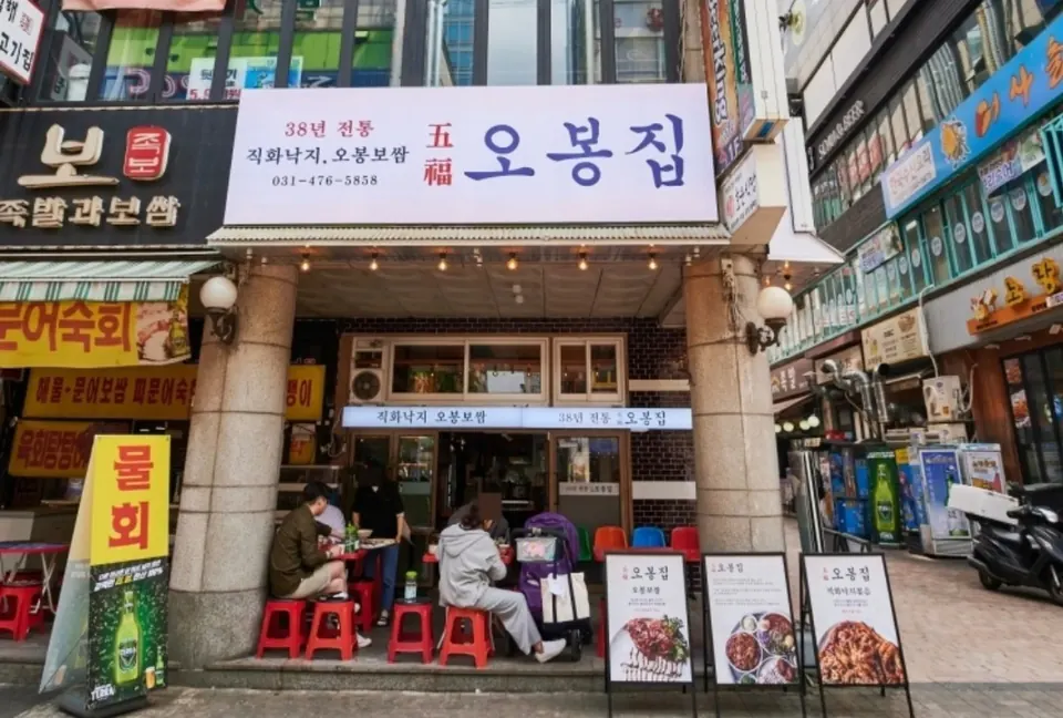 오봉집 범계 매장 외관, 건물 1층 입구에 간판과 입간판이 놓인 점포
