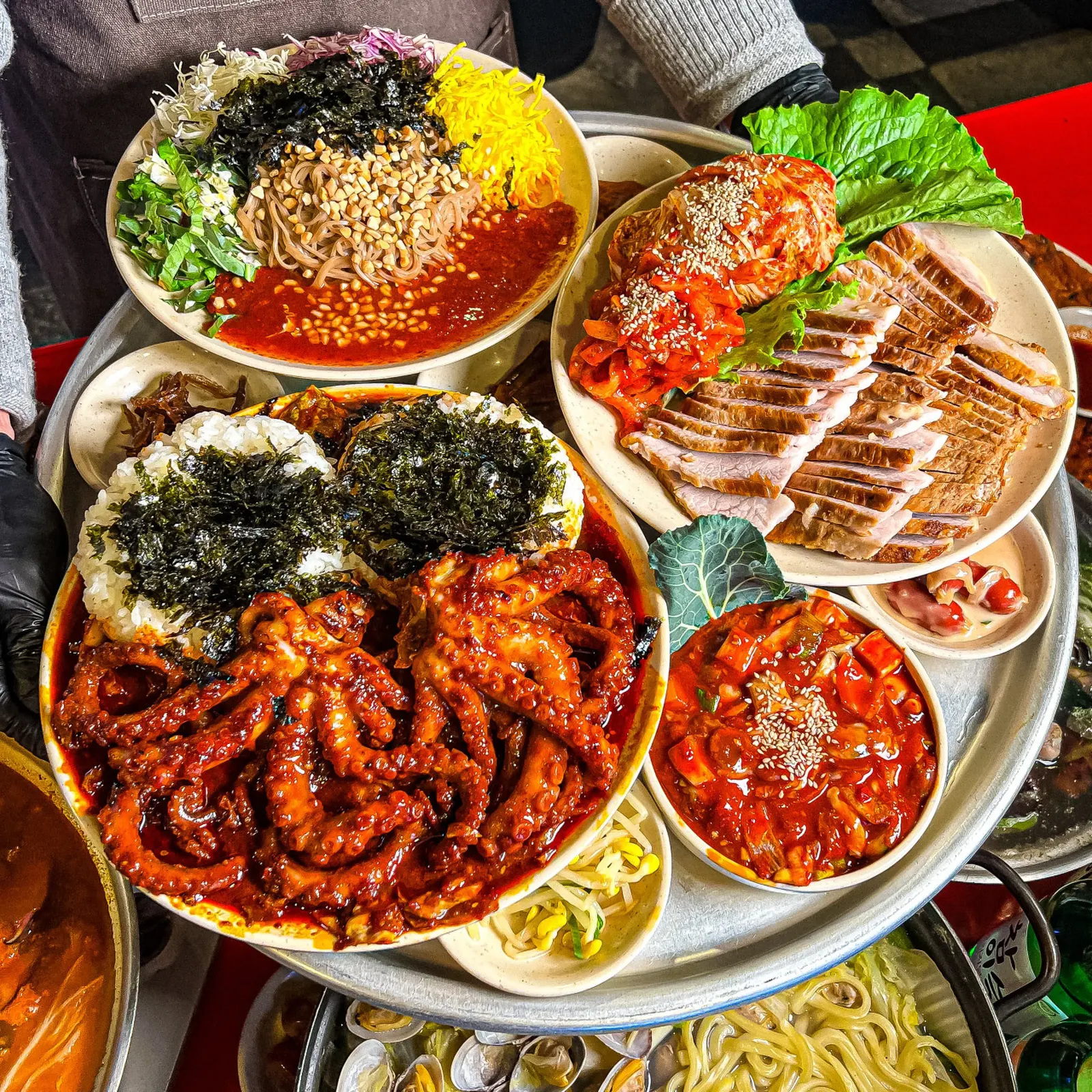 낙지볶음과 보쌈, 비빔밥, 조개 요리가 함께 올라간 오봉집 한상 차림