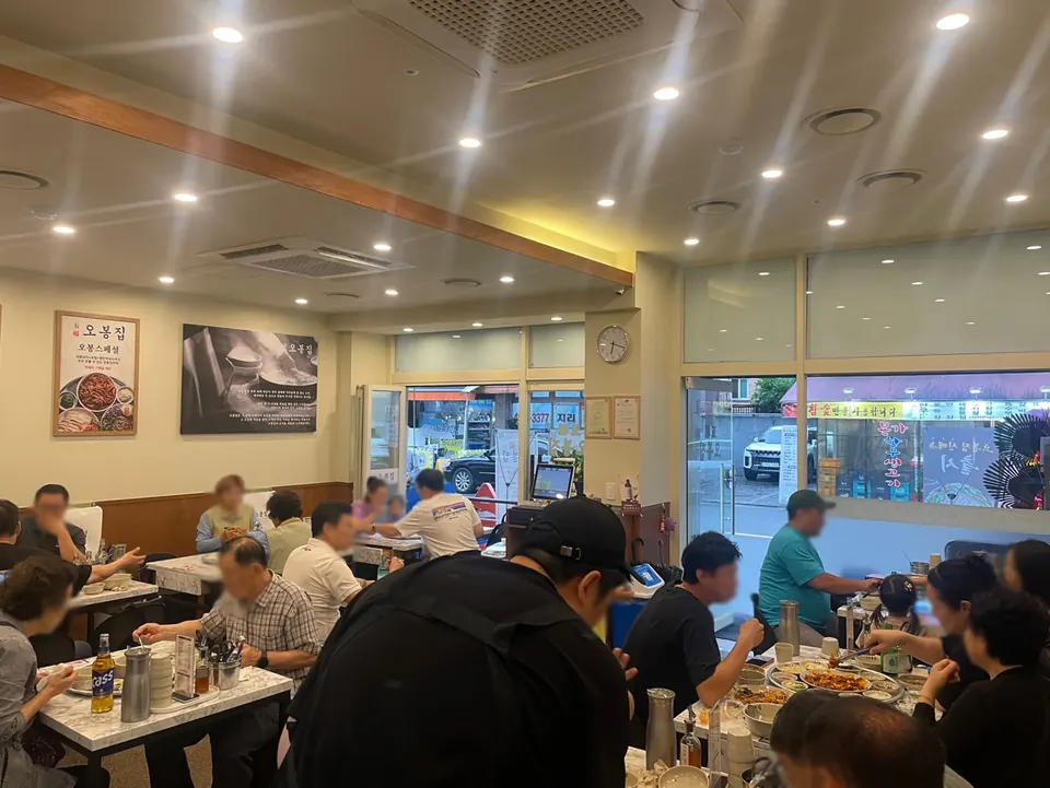 밝은 조명과 테이블 좌석이 줄지어 놓인 오봉집 매장 내부 홀