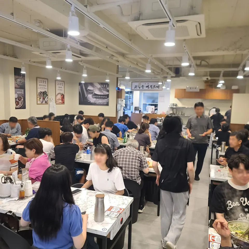모자이크 처리된 손님들이 식사 중인 오봉집 매장 내부 홀